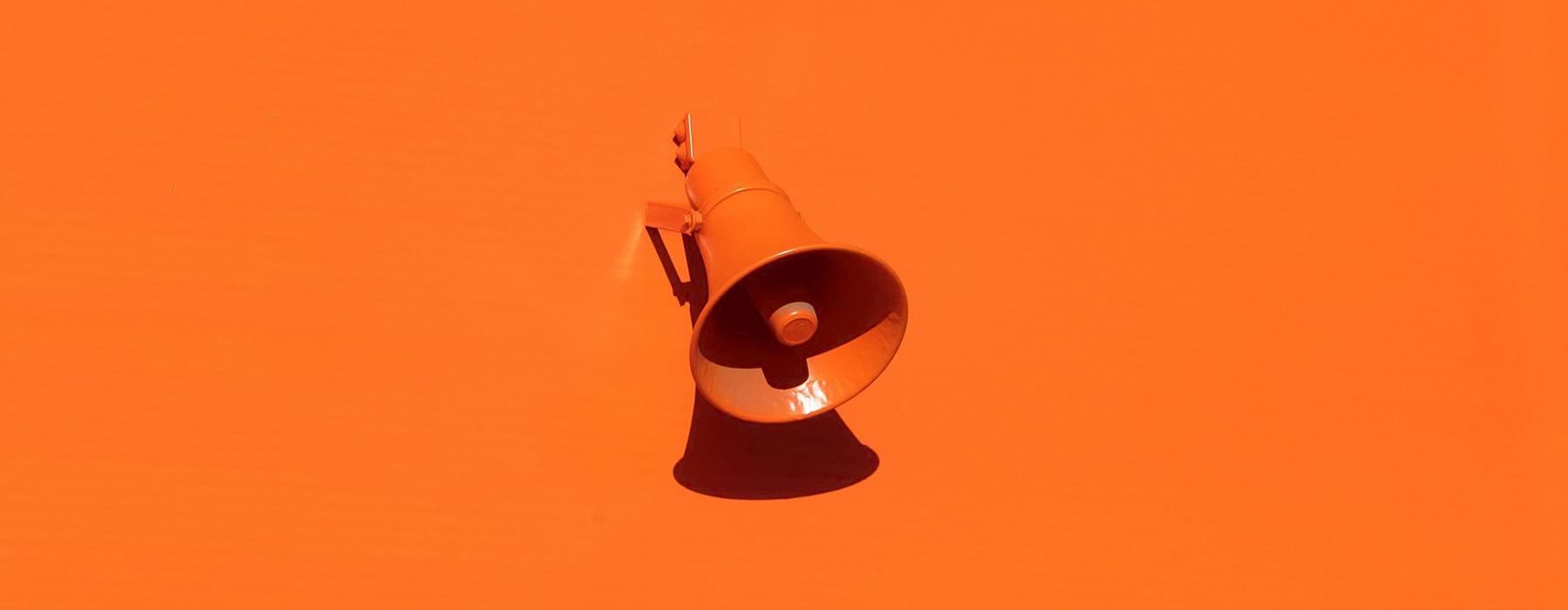 orange wall with an orange speaker attached to it
